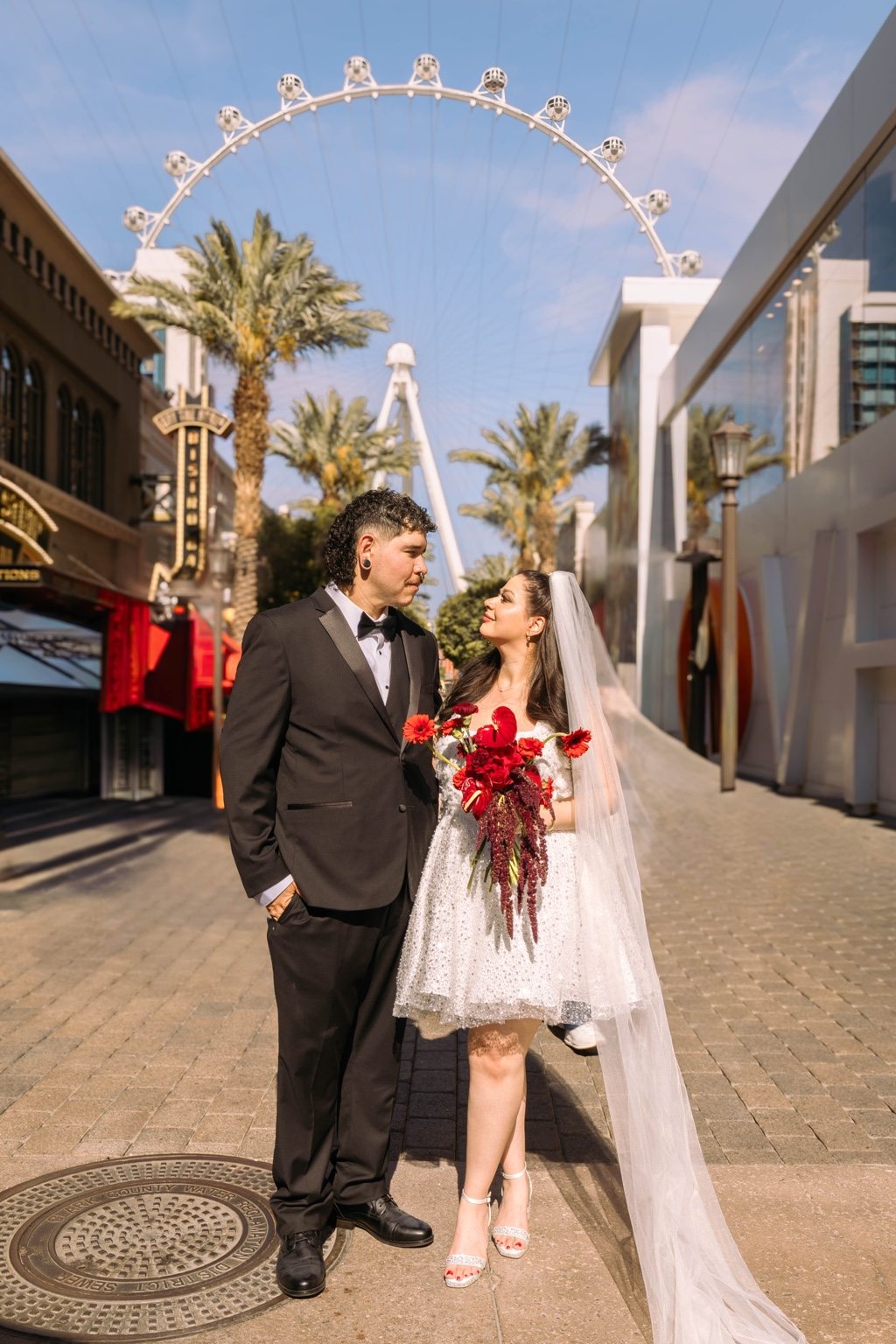 Las Vegas elopement couple holding a vivid red bridal bouquet